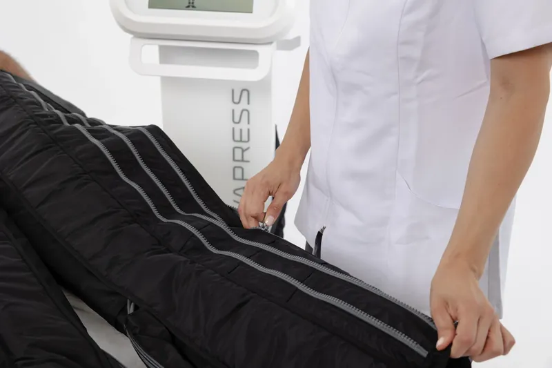 Behandlung mit NOVApress: Beine in Kompressionsmanschetten auf der Liege